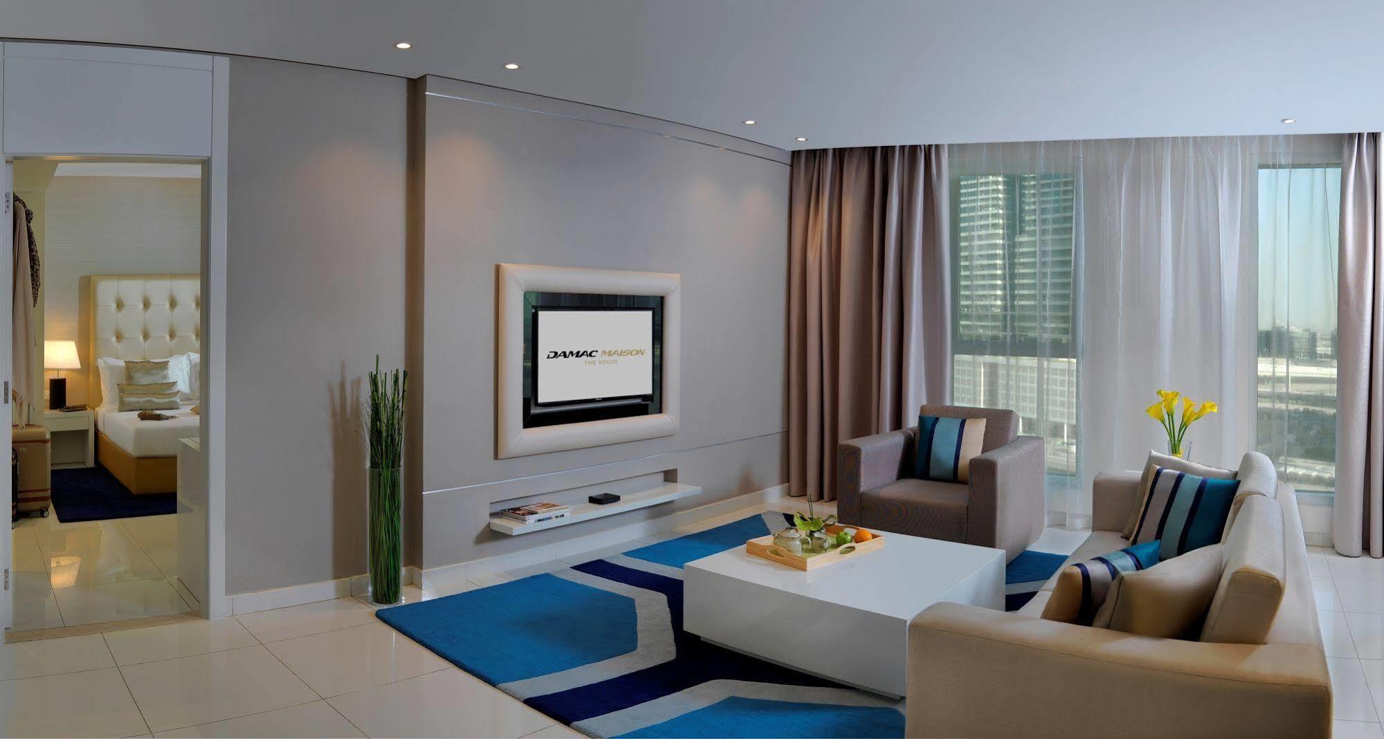 Damac Maison The Vogue Dubai Bagian luar foto A living room with a television